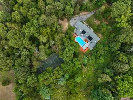 an aerial view of a house with a yard and swimming pool