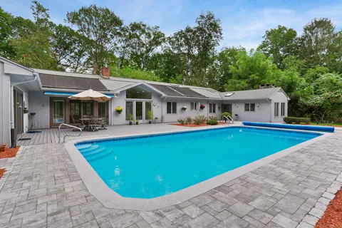 swimming pool view with a seating space and a garden view
