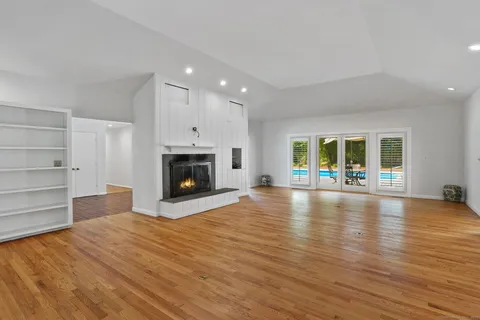 a view of a livingroom with wooden floor and a fireplace