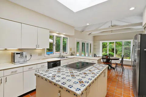 a kitchen with a stove a sink dishwasher a refrigerator and cabinets with wooden floor