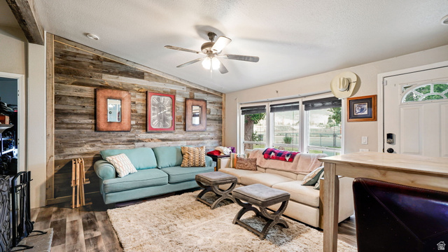 490 South Main Street Kamas, UT 84036 - Photo 4 of 25 Living area featuring a distinctive wood plank accent wall, wood-finish flooring, and a ceiling fan