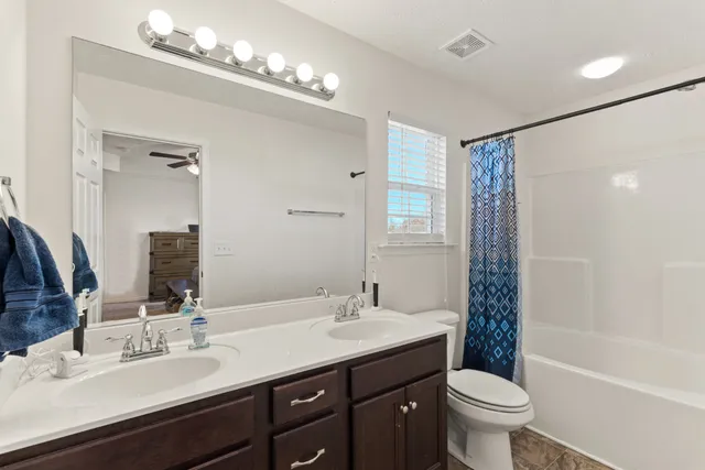 a bathroom with a sink double vanity granite tub and a mirror