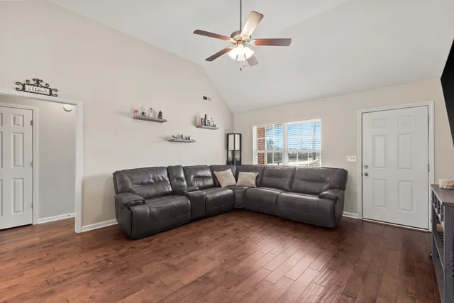 a living room with furniture and a wooden floor