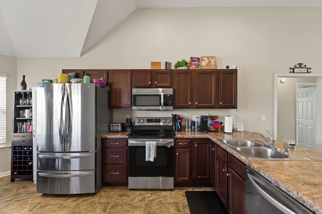 a kitchen with stainless steel appliances granite countertop a refrigerator stove and sink