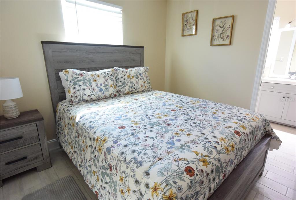 170 Argus Road Venice, FL 34293 - Photo 21 of 36 a large bed sitting in a bedroom next to a window