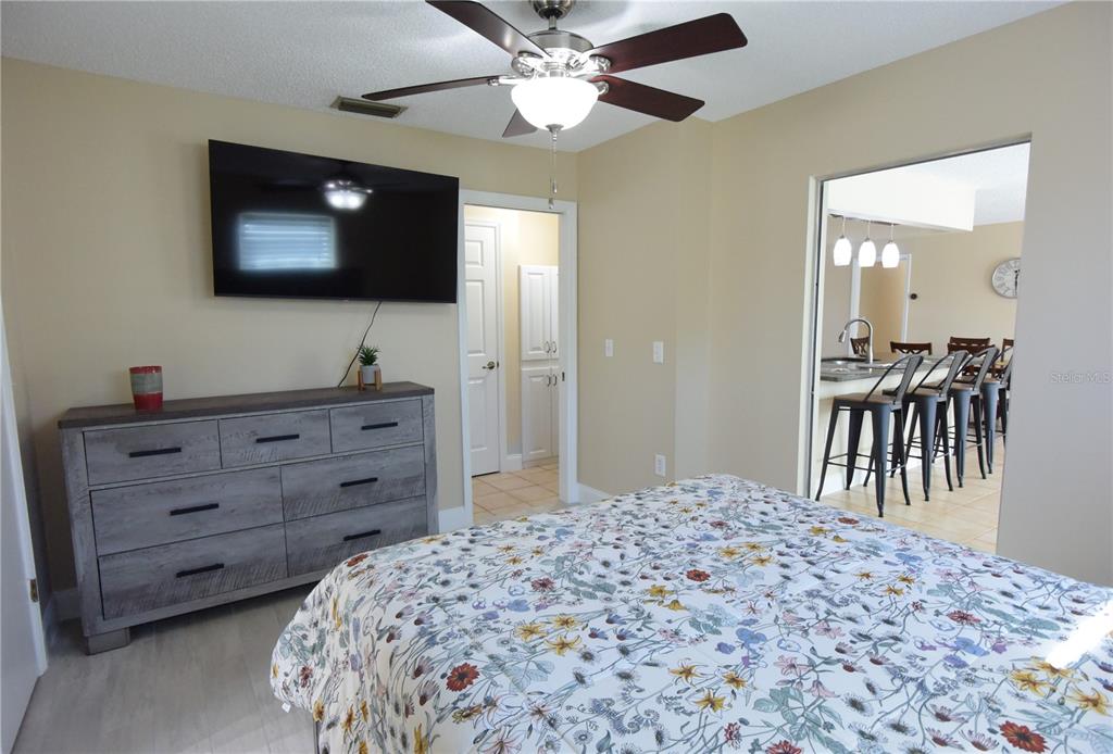 170 Argus Road Venice, FL 34293 - Photo 22 of 36 a bedroom with a bed and a flat screen tv