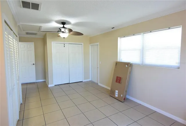 a view of a livingroom with a chandelier fan and windows