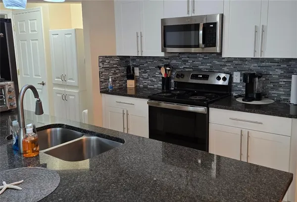 a kitchen with granite countertop a stove and a sink