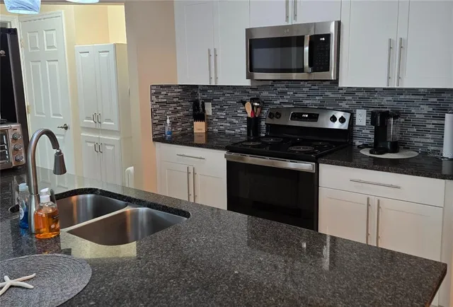 a kitchen with granite countertop a stove and a sink