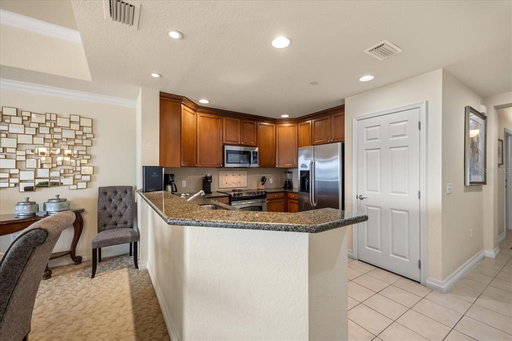 1114 Sunset View Circle, Unit 402 Reunion, FL 34747 - Photo 5 of 32 a kitchen with stainless steel appliances granite countertop a sink refrigerator and cabinets