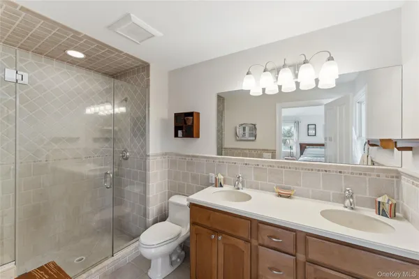 a bathroom with a double vanity sink mirror and toilet