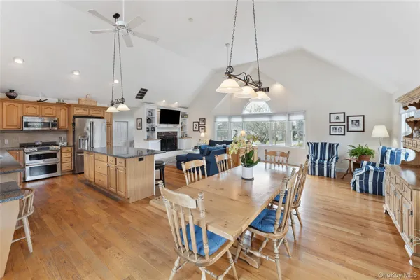 a view of a dining room and livingroom with furniture wooden floor a chandelier