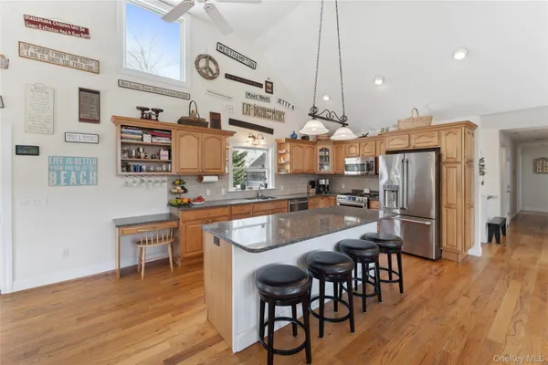 a kitchen with stainless steel appliances granite countertop a table chairs stove and wooden floor