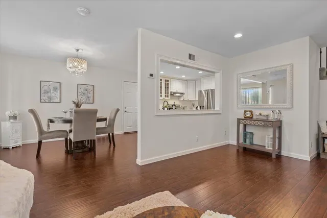 a living room with furniture wooden floor and a kitchen view