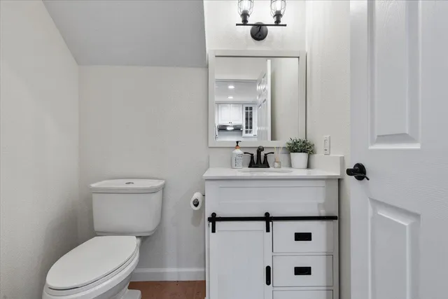 a bathroom with a sink mirror vanity and toilet