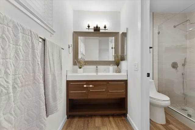 a bathroom with a sink vanity mirror and toilet