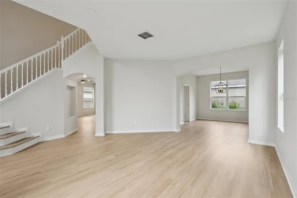 a kitchen with stainless steel appliances kitchen island a refrigerator a stove a sink dishwasher and a oven with wooden floor