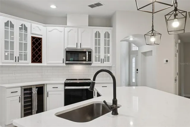 a kitchen with a sink a microwave a stove and cabinets
