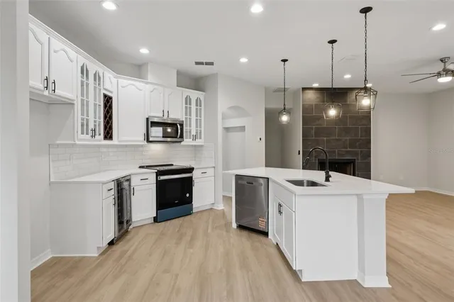 an empty room with windows and fireplace