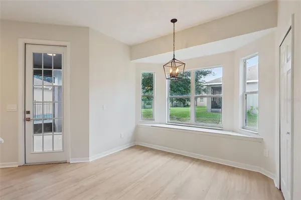a view of empty room with wooden floor and window