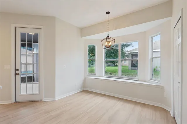 a view of empty room with wooden floor and window