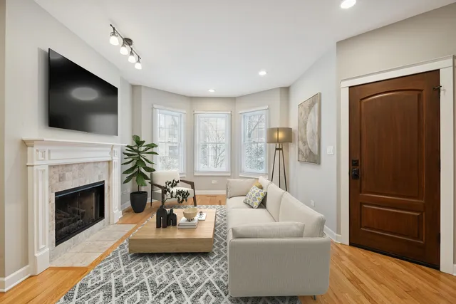a living room with furniture a flat screen tv and a fireplace