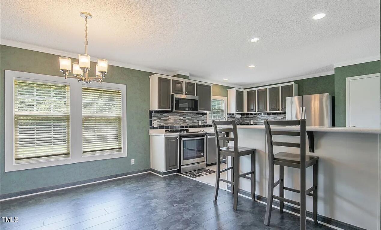 2455 McLean Chapel Church Road Bunnlevel, NC 28323 - Photo 7 of 21 a kitchen with stainless steel appliances granite countertop a stove and a refrigerator