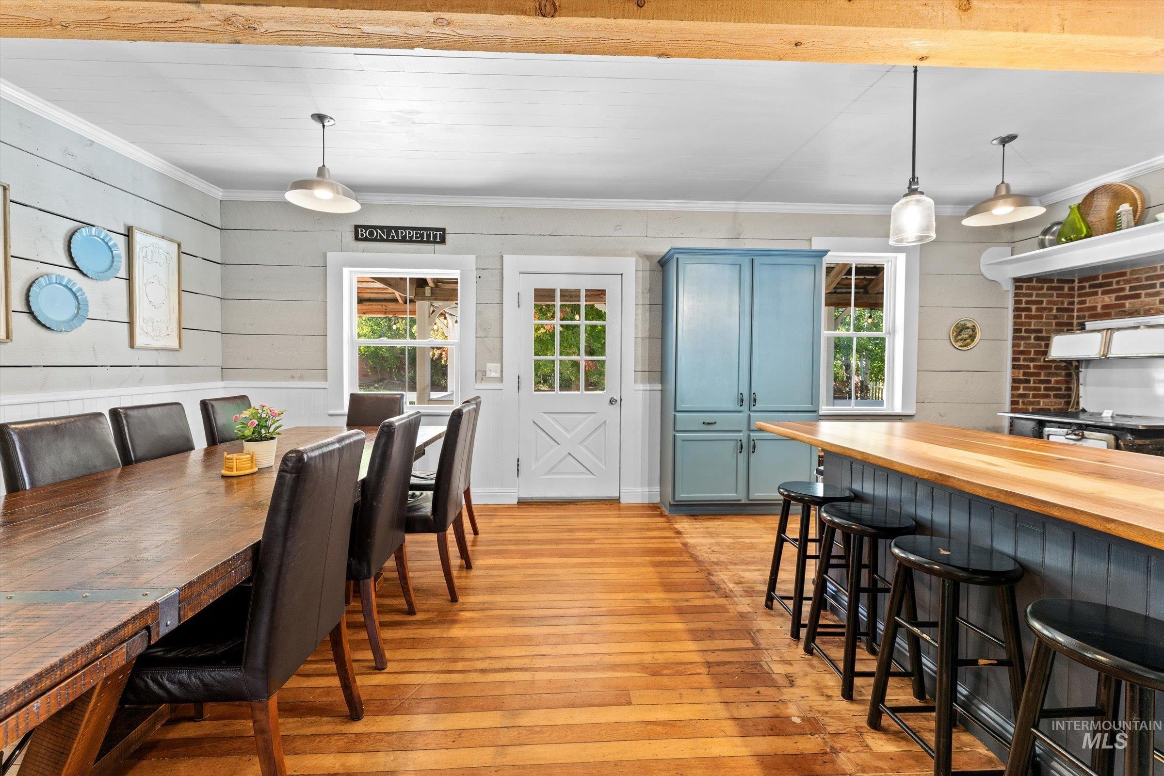315 South Middlefork Road Garden Valley, ID 83622 - Photo 9 of 49 Dining area featuring light wood-style floors, ornamental molding, and wood walls