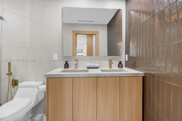 a bathroom with a sink a toilet and a mirror