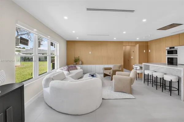 a living room with furniture and large windows