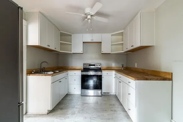 a kitchen with granite countertop a sink stove and cabinets