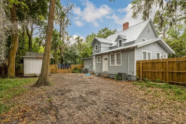 a view of a house with backyard and a tree