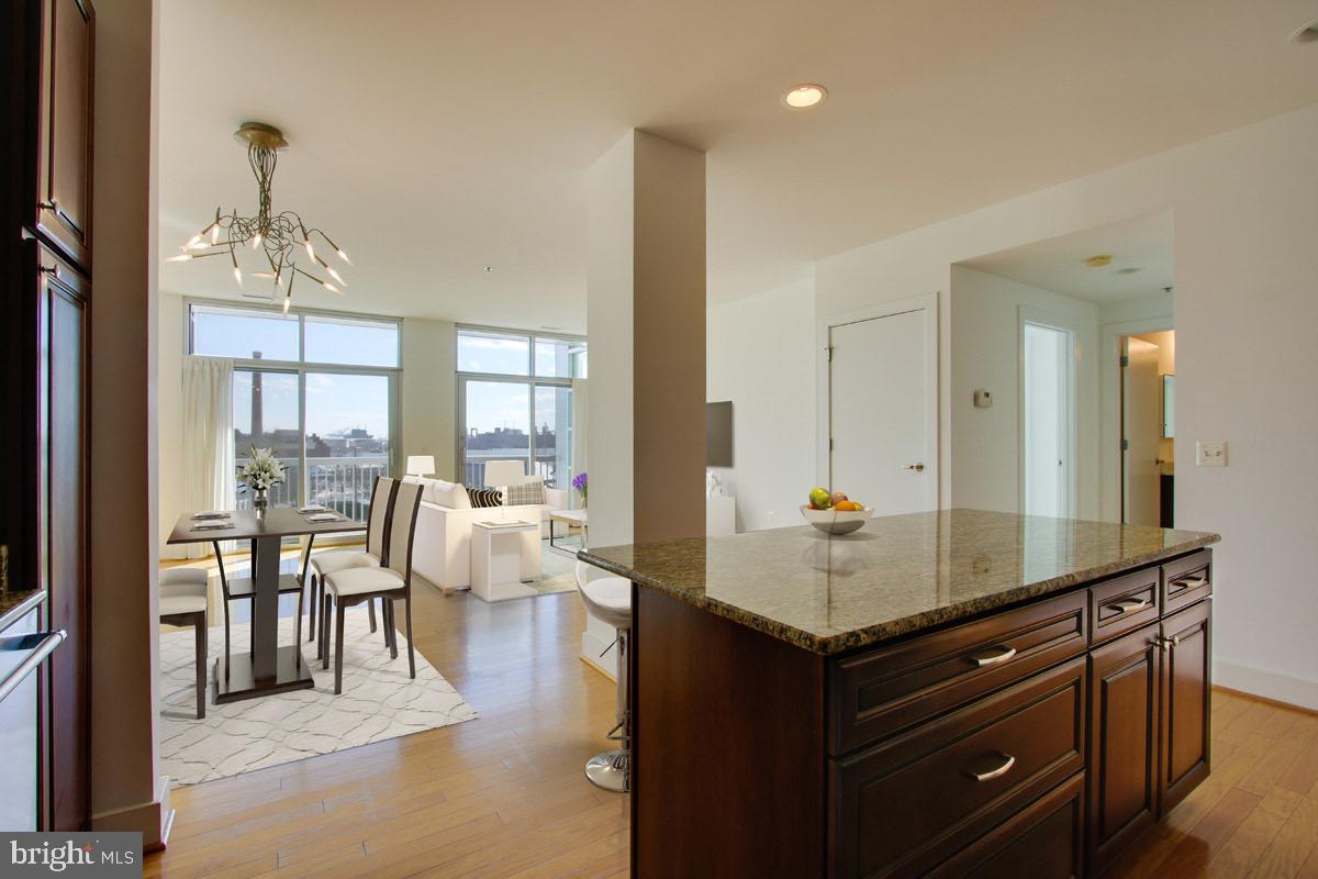 2772 Lighthouse Point East, Unit 308 Baltimore, MD 21224 - Photo 1 of 6 a living room with granite countertop kitchen island furniture and a view of living room