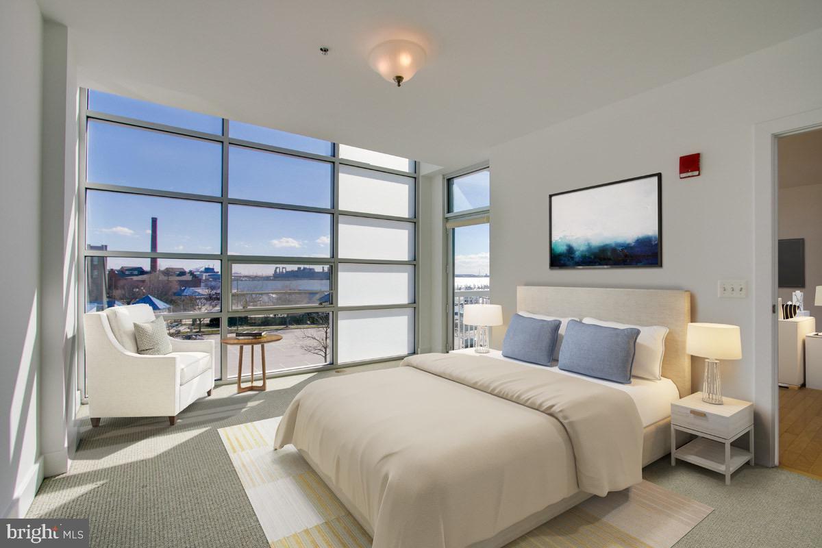 2772 Lighthouse Point East, Unit 308 Baltimore, MD 21224 - Photo 5 of 6 a bedroom with a large bed and a couch