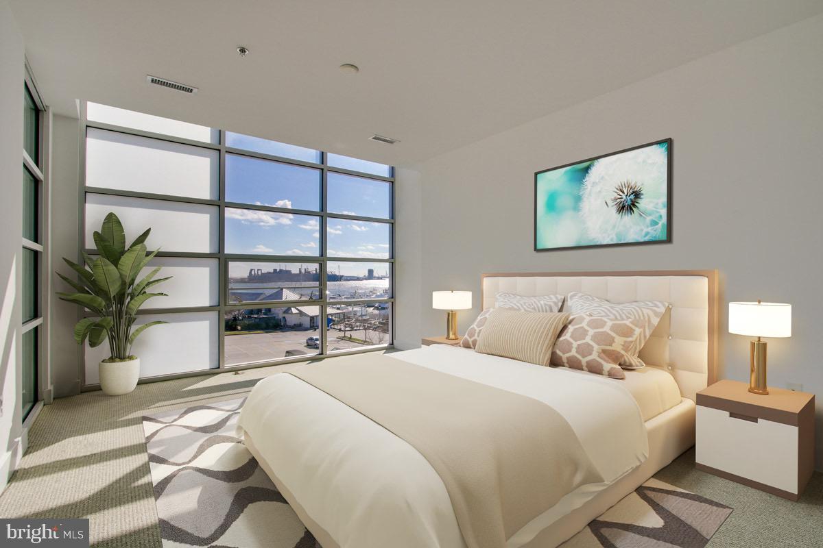 2772 Lighthouse Point East, Unit 308 Baltimore, MD 21224 - Photo 6 of 6 a bedroom with a large bed and a large window