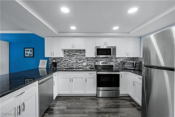 a kitchen with white cabinets and sink
