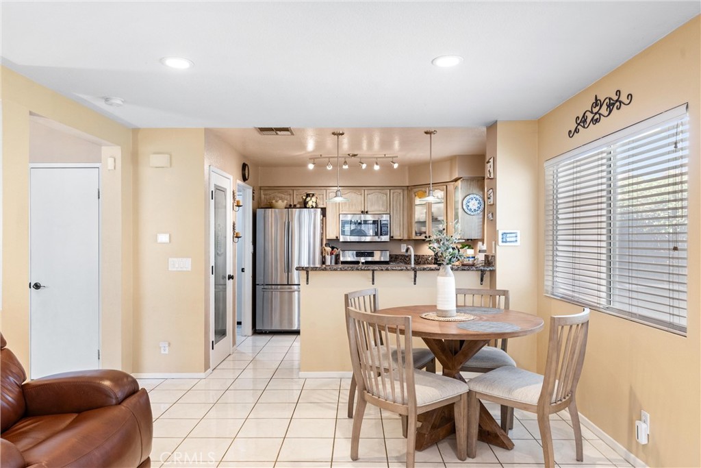 861 Shade Tree Way Corona, CA 92878 - Photo 12 of 47 Stylish drop down light fixtures above granite breakfast counter bar