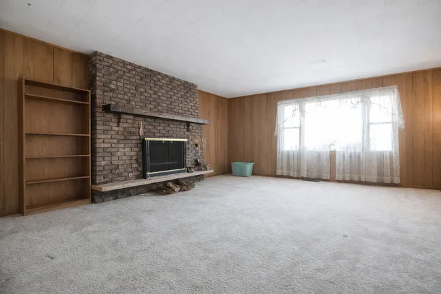 an empty room with a fireplace and window