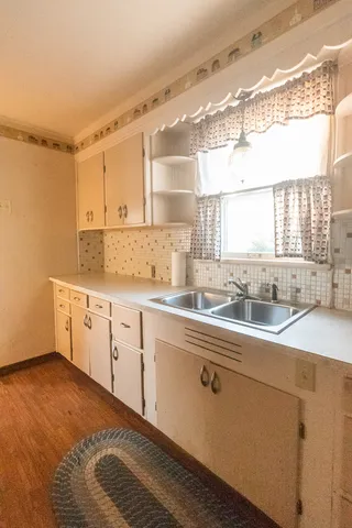 a kitchen with granite countertop white cabinets and white appliances