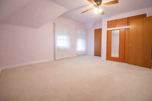 a view of an empty room with a ceiling fan
