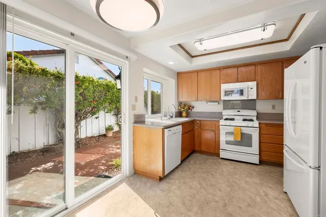 a kitchen with stainless steel appliances granite countertop a refrigerator a stove top oven a sink and dishwasher