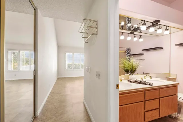 a bathroom with a granite countertop sink a large mirror and a toilet