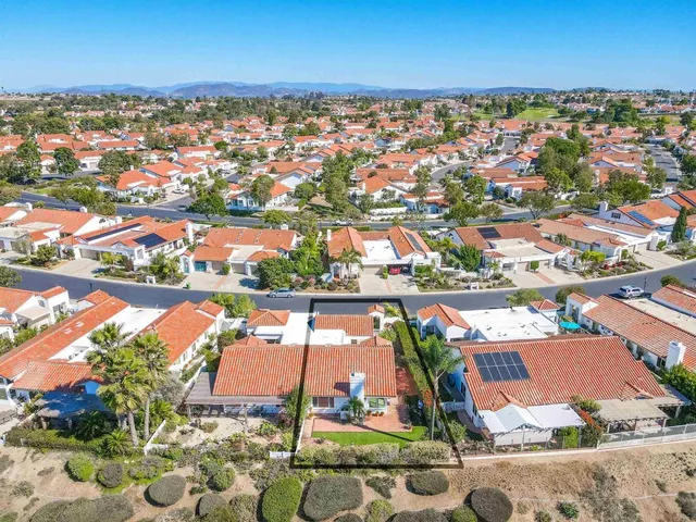 an aerial view of residential houses with outdoor space and mountain view