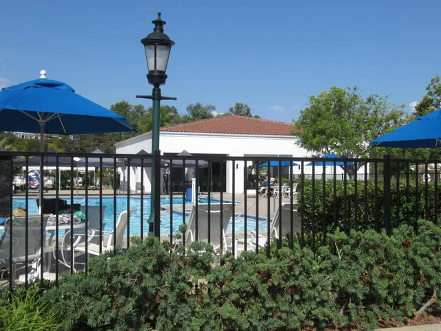 a view of a swimming pool with a table and chairs under an umbrella