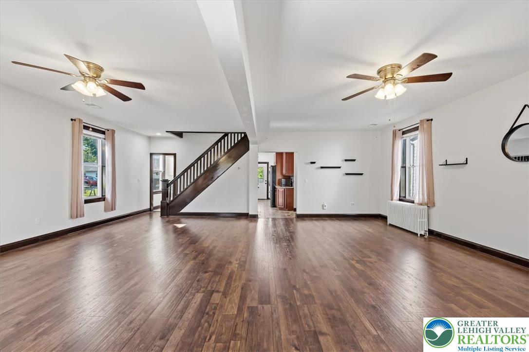 3453 Main Street Slatington, PA 18080 - Photo 3 of 30 Natural light bathes this spacious living area, highlighting the rich hardwood flooring and classic staircase.