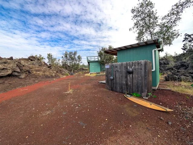 a view of a wooden house with a large tree
