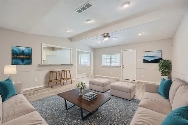 a living room with furniture and a wooden floor