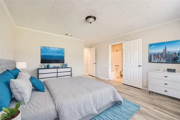 a bedroom with a bed and a painting on the wall