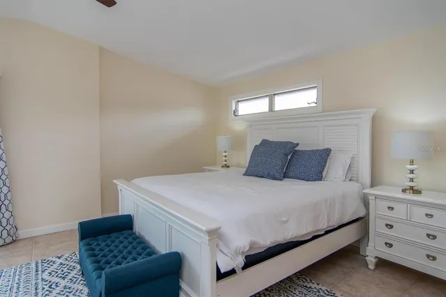 a spacious bedroom with a bed and a chandelier