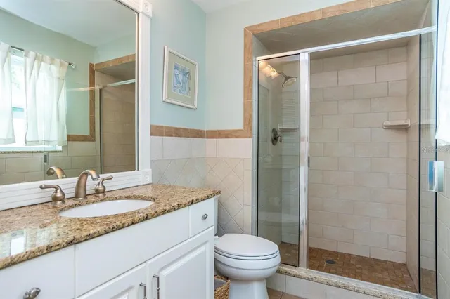 a bathroom with a granite countertop sink toilet and shower